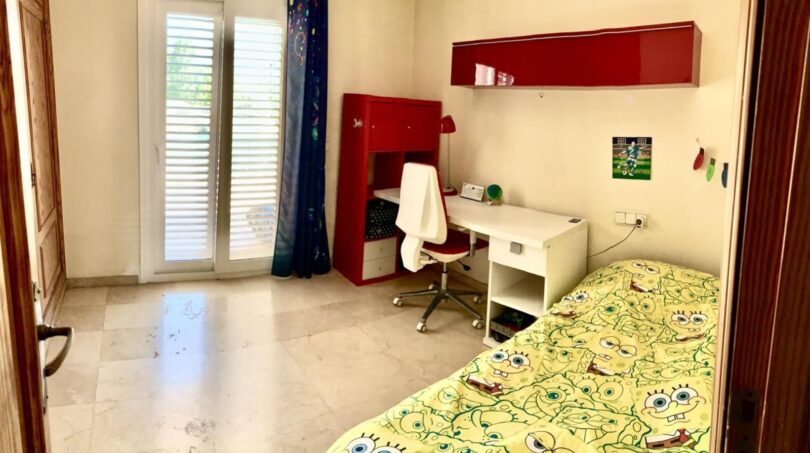 Kinderzimmer des Chalets in Marratxí mit SpongeBob-Bettwäsche, rotem Schreibtisch, Drehstuhl und Balkonzugang.