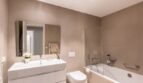 Modern bathroom of the new ground-floor apartment in La Vileta with bathtub, shower and white sink.