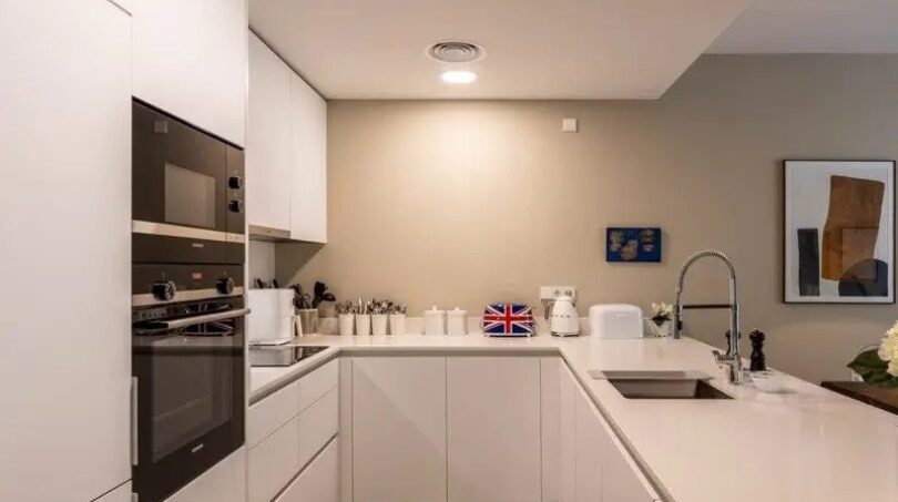 Modern white fitted kitchen with Bosch appliances, quartz stone worktops and kitchen island in new ground-floor apartment La Vileta