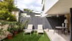 Well-maintained outdoor area of the ground-floor apartment in La Vileta with artificial grass, sun loungers and dining area.