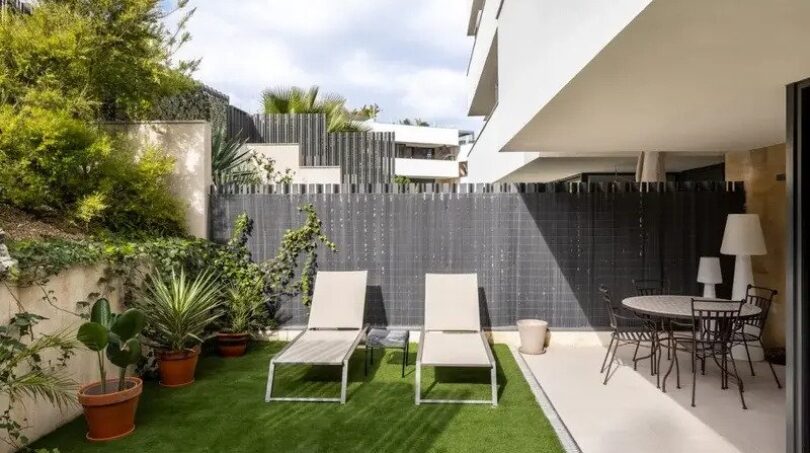 Well-maintained outdoor area of the ground-floor apartment in La Vileta with artificial grass, sun loungers and dining area.