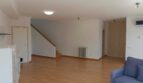 Helles Wohnzimmer mit Holzboden, Treppe, Heizkörper und blauem Sofa im Reihenhaus La Vileta