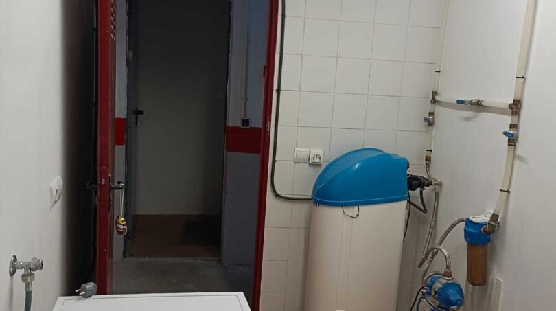 Practical utility bathroom with separate shower cabin and central hot water supply - Efficient fixtures