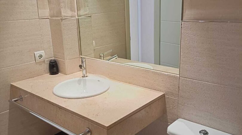 Modern bathroom with marble washbasin, mirror, toilet and shower in the La Vileta townhouse, Palma