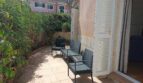 Sonnige Terrasse mit Rattanmöbeln, umgeben von Grünpflanzen, mit Zugang zum Wohnbereich des Reihenhauses in La Vileta.