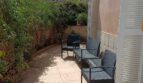 Sonnige Terrasse mit Rattanmöbeln und üppigem Grün beim Reihenhaus in La Vileta, Palma