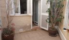Sonniger Innenhof des Reihenhauses in La Vileta mit Terrakotta-Fliesen, Topfpflanzen und Zugang zur Küche.