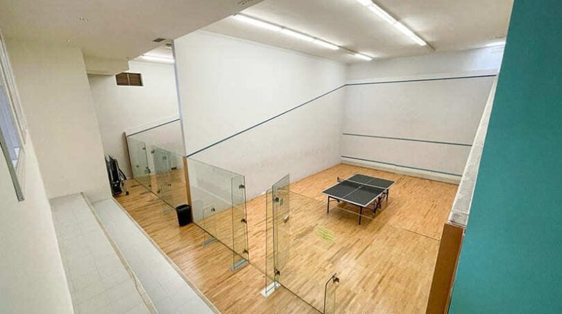 Squashplatz mit Glaswänden und Tischtennistisch im Freizeitbereich des Apartments in El Toro