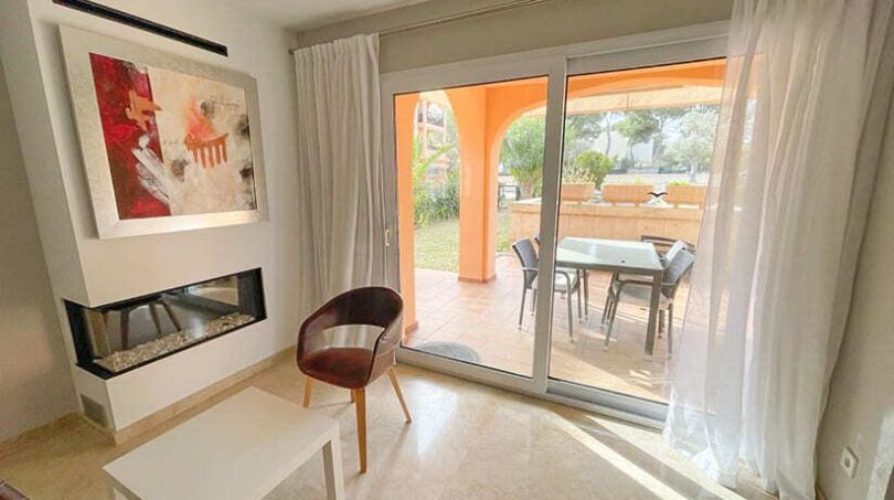 Helles Wohnzimmer mit Kamin, modernem Sessel und Terrassenzugang zum privaten Garten in El Toro