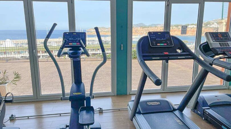 Fitnessraum mit Laufbändern und Ellipsentrainer, großen Panoramafenstern und Meerblick in El Toro