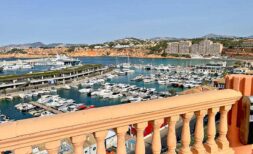 Balcony with balustrade and panoramic view of El Toro yacht harbor, Calvia, with mountains in the background