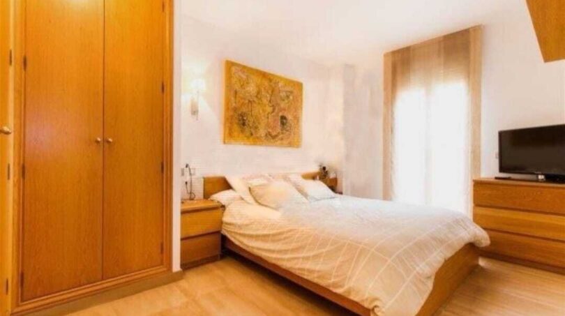 Helles Schlafzimmer mit Doppelbett, Holzschrank und TV in Erdgeschosswohnung Palma de Mallorca