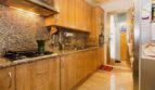 Moderne Küche mit Holzfronten, Granitarbeitsplatte, Gasherd und Einbaugeräten in Erdgeschosswohnung Palma