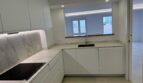 Modernes Penthouse-Küche in Palma mit Marmoroptik, weißen Fronten und Kochfeld