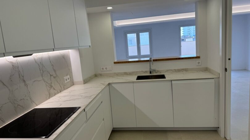 Modernes Penthouse-Küche in Palma mit Marmoroptik, weißen Fronten und Kochfeld