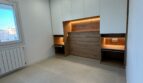 Modernes Penthouse-Zimmer in Palma mit Einbauschränken, LED-Holznische, Klappbett und hellem Steinboden.