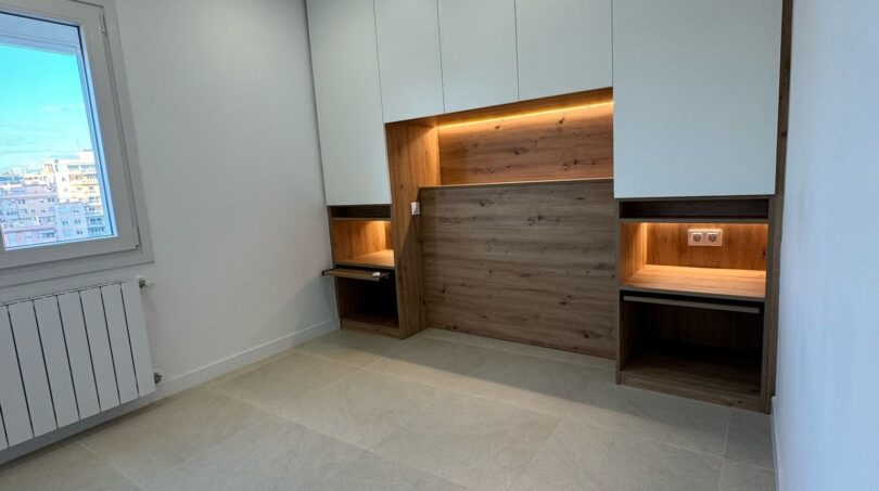 Modernes Penthouse-Zimmer in Palma mit Einbauschränken, LED-Holznische, Klappbett und hellem Steinboden.