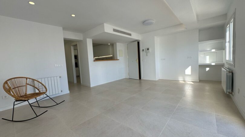 Helles, weitläufiges Wohnzimmer im Penthouse mit Granitboden, Einbauküche und modernem Design in Palma de Mallorca.