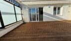 Geräumige Dachterrasse mit Holzboden, Glasschiebetür und Markise des Penthouse in Palma de Mallorca