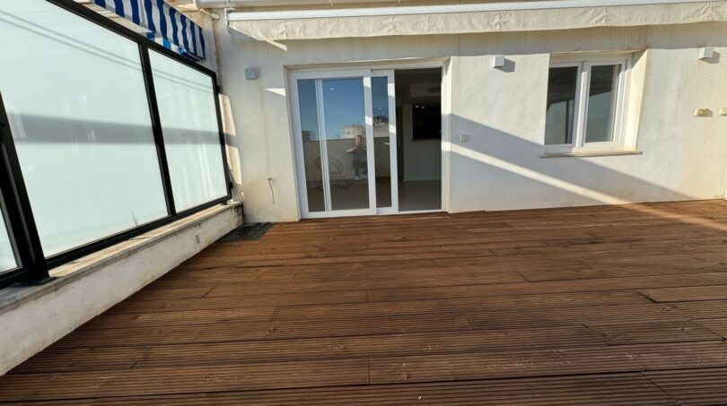 Geräumige Dachterrasse mit Holzboden, Glasschiebetür und Markise des Penthouse in Palma de Mallorca