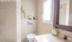 Bright bathroom with beige tiles, shower, toilet and window in the chalet with sea view in Puerto Adriano