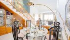 Elegant dining room with glass table, black designer chairs and open living area in the chalet in Puerto Adriano.