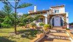 Exterior view of Puerto Adriano chalet: Mediterranean villa with arcade entrance, terracotta steps and tropical garden.