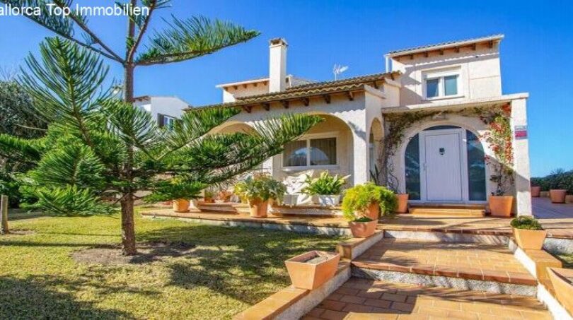 Exterior view of Puerto Adriano chalet: Mediterranean villa with arcade entrance, terracotta steps and tropical garden.