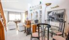 Living room of the chalet in Puerto Adriano with dining table, white sofas and decorative vintage elements.