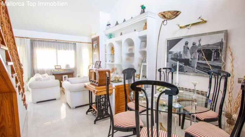 Living room of the chalet in Puerto Adriano with dining table, white sofas and decorative vintage elements.