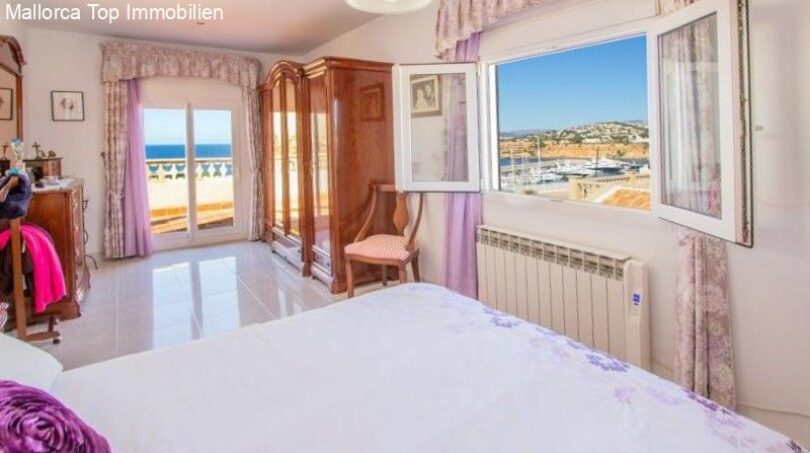 Bright bedroom with sea view, wooden wardrobe, radiator and purple accents in chalet, Puerto Adriano.