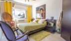 Bright bedroom in Port Adriano chalet with double bed, yellow curtains and modern ambiance.
