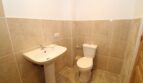 Helles Gäste-WC der Finca mit Waschbecken und WC, beige Marmoroptik-Fliesen, gepflegt und funktional.