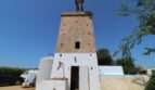 Historische Windmühle aus Sandstein mit weißem Sockelgebäude und Pool auf Finca in Son Ferriol