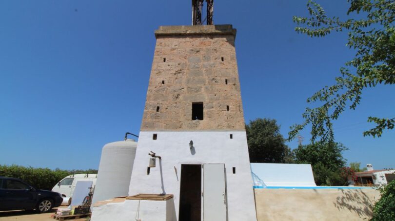 Historische Windmühle aus Sandstein mit weißem Sockelgebäude und Pool auf Finca in Son Ferriol