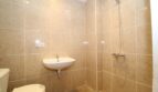 Helles Badezimmer der Finca mit beigen Marmorfliesen, Dusche, Waschbecken und WC.