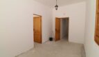 Leerer Zimmer der Finca in Son Ferriol mit zwei Holztüren, weißen Wänden und Betonboden.