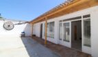 Überdachte Terrasse der Finca in Son Ferriol mit Holzbalken, Terrakottafliesen und großen Glastüren zum Innenbereich.