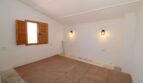 Leeres Schlafzimmer der Finca in Son Ferriol mit Holzfensterladen und zwei Wandleuchten