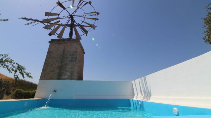 Pool mit Wassereinlauf und historischer Windmühle der Finca in Son Ferriol, Palma
