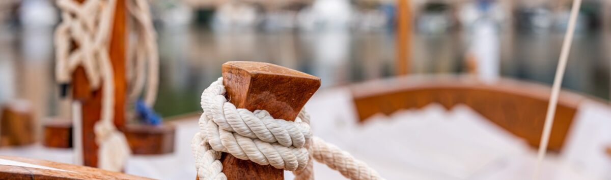 Wooden sailing boat with white rope in the Mediterranean harbor of Bendinat – pure Mediterranean flair.