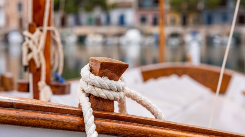 Wooden sailing boat with white rope in the Mediterranean harbor of Bendinat – pure Mediterranean flair.