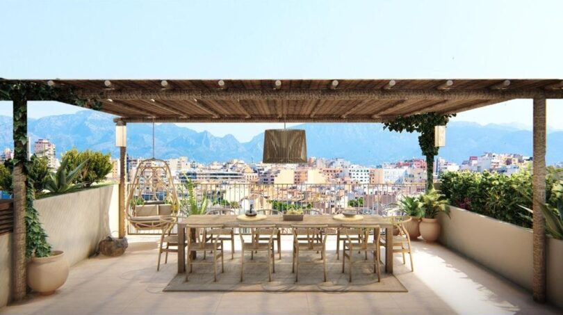 Luxuriöse Dachterrasse mit Pergola, Esstisch und Stadtblick auf Palma de Mallorca mit Bergpanorama.