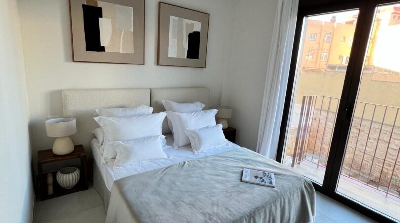 Helles Schlafzimmer mit Doppelbett, abstrakten Wandbildern und Balkon mit Stadtblick in Palma de Mallorca