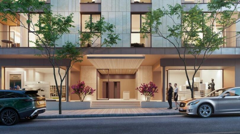 Elegante Außenfassade eines Luxusapartments in Palma de Mallorca mit beleuchtetem Eingang und Bäumen.