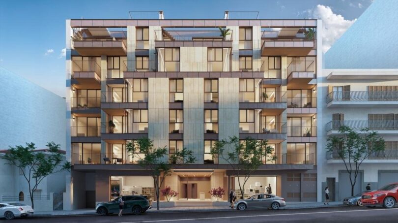 Modernes Mehrfamilienhaus in Palma de Mallorca mit Balkonen, Glasfassade und beleuchtetem Eingangsbereich bei Abenddämmerung.