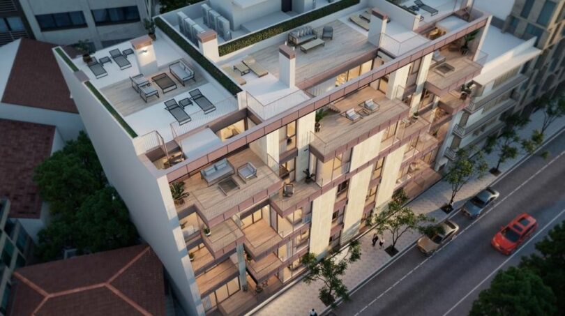 Modernes Mehrfamilienhaus in Palma mit großzügigen Balkonen, Dachterrasse und Loungemöbeln aus der Vogelperspektive.
