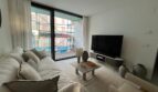 Helles Wohnzimmer mit großem Flachbildschirm, Balkonzugang und modernem Sofa in Palma de Mallorca