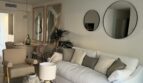 Helles Wohnzimmer mit weißem Sofa, Rundspiegeln und elegantem Couchtisch in Luxusapartment Palma