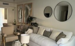 Helles Wohnzimmer mit weißem Sofa, Rundspiegeln und elegantem Couchtisch in Luxusapartment Palma